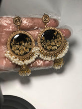 Handmade black and gold resin jhumka earrings with pearl accents and a glossy resin finish.