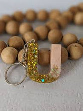 Dual-colour epoxy resin alphabet keychain with glossy finish and personalized initial.