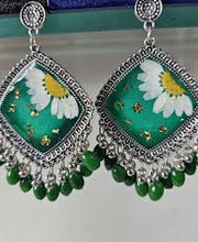 Handmade green resin jhumka earrings featuring white flowers inside a glossy resin dome.