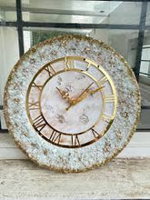 Off-white and gold resin geode wall clock with Roman numerals.