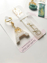 Custom colour resin keychain and bookmark set with glossy finish.