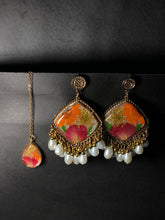 Handmade resin jhumka earrings and matching pendant set with dried flowers and white faux pearls.